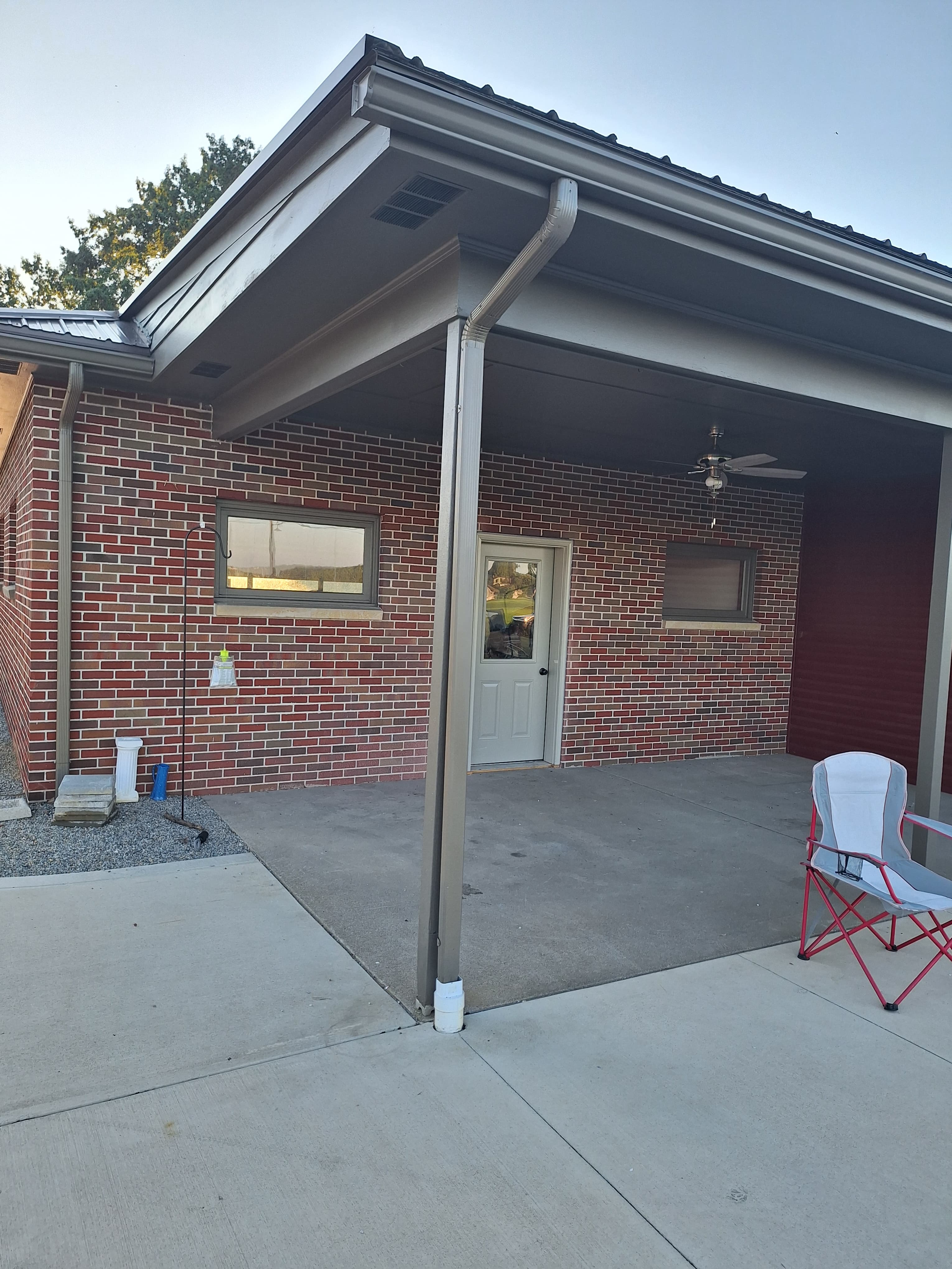 Exterior view of a brick building with a covered patio and gray trim.