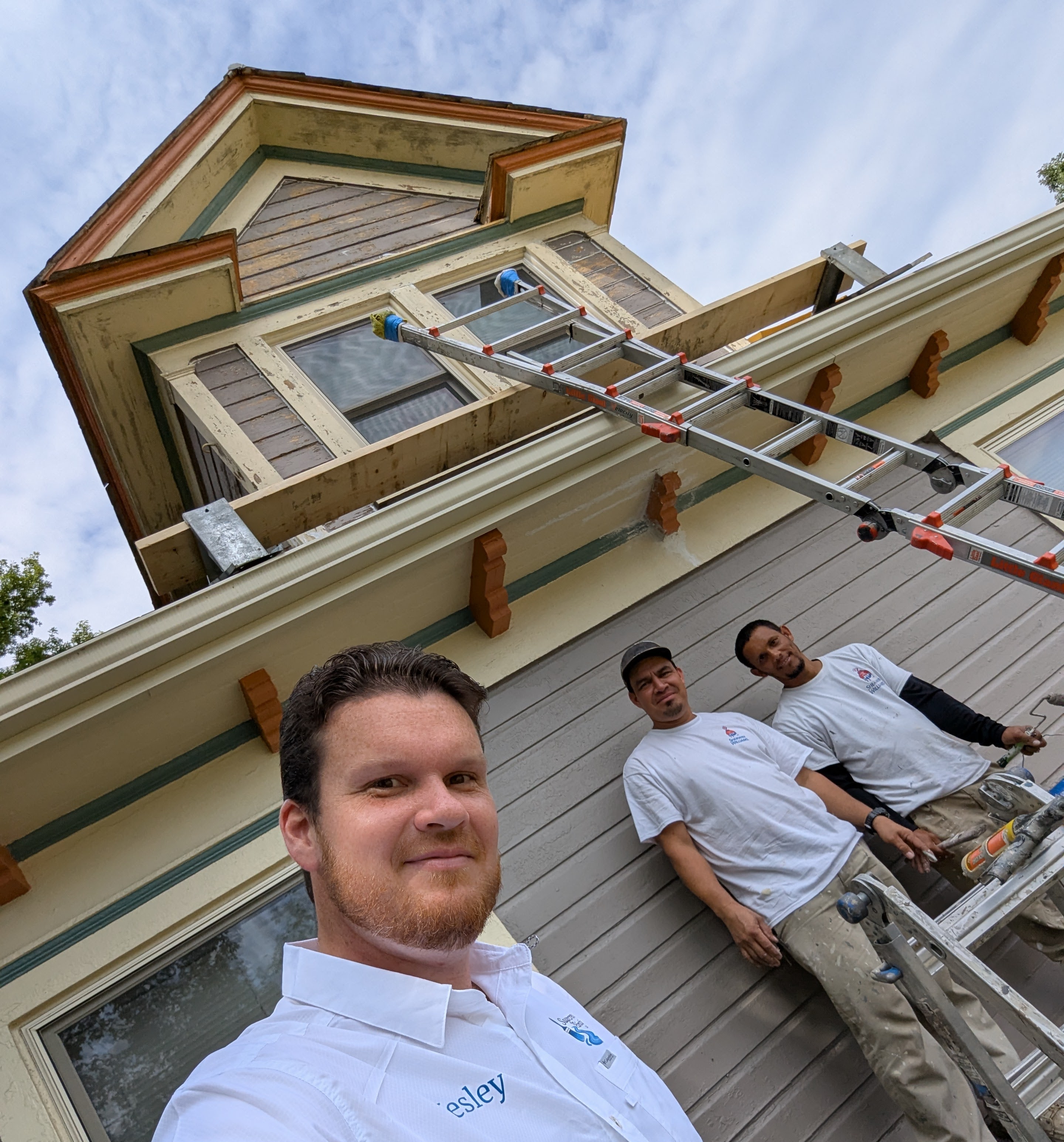 Painting crew working on a home's exterior trim and siding.